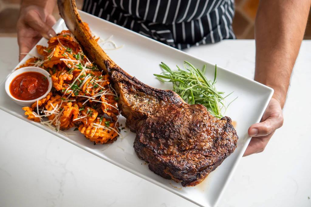 Juicy Wagyu Tomahawk steak on a plate at Bourbon Steak Miami.