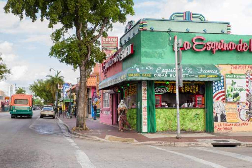 A bustling ventanita window in Little Havana serving steaming coladas to eager Miamians at dawn.