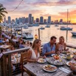 Outdoor waterfront restaurant in Miami with sunset views, boats, and diners enjoying fresh seafood